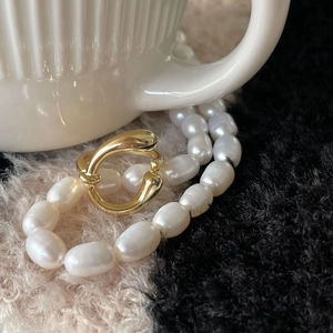 Minimalist 925 silver U-ring with baroque pearl chain set against a white ceramic mug
