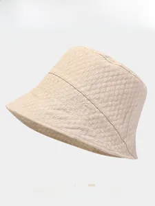 Detail of light beige sun hat showing unique bubble texture fabric and foldable design