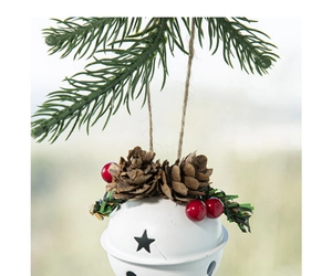 White metal Christmas bell detail with pine cones, red berries and green ribbon bow