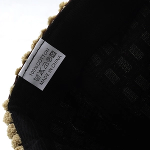 Detailed close-up of the 100% cotton label and fabric texture on a winter baseball cap