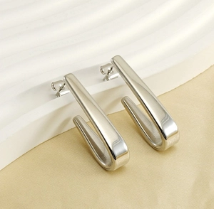Vue macro détaillée de boucles d'oreilles en acier inoxydable argenté en forme de U