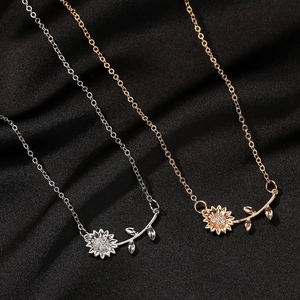 Detail of silver and gold sunflower pendants with micro-inlaid rhinestones on black satin