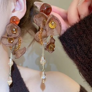 Detail of long brown mesh flower earrings with crystal tassel and golden chains