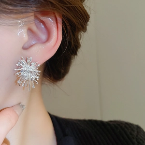 Close-up of sparkling silver firework stud earring with diamonds on a female model