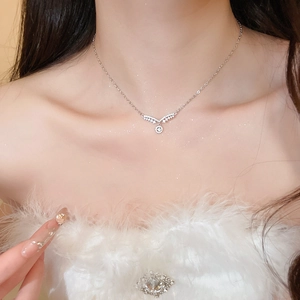 Détail d'un collier pendentif en zircon étincelant avec motif ailes et chaîne argent