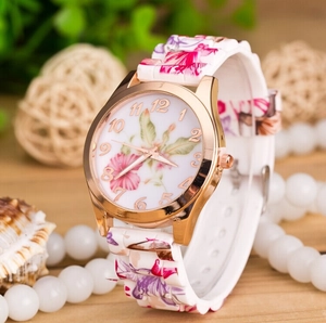 Floral print silicone watch with rose gold case styled on a rustic wooden surface