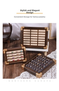 Detail view of walnut wood jewelry trays with gold corners and soft velvet ring slots