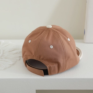Detail of adjustable strap and breathable eyelets on baby soft brim baseball cap