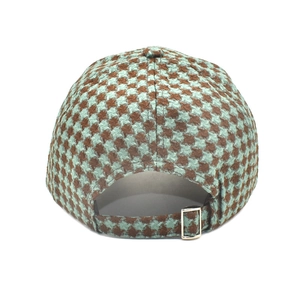 Detail of houndstooth baseball cap featuring adjustable golden metal buckle back strap