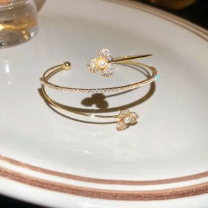 Close-up of golden floral bracelet with pearls and sparkling cubic zirconia details