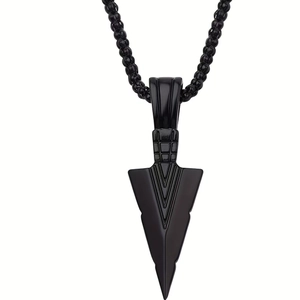 Close-up of black metal nail cross pendant with geometric engraving on beaded chain
