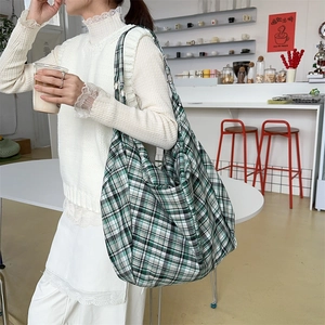 Detail der grünen karierten Tragetasche mit großem Fassungsvermögen im Café