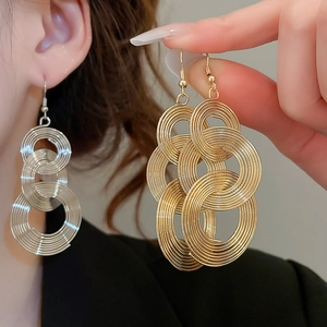 Detailed close-up of interlocking metal circle earrings in gold and silver finish