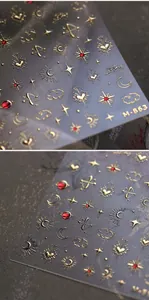 Dettaglio ravvicinato degli adesivi per nail art dorati M-863 con motivi di stelle e luna
