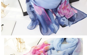 Detail of a thin light blue chiffon scarf with pink floral pattern for sun protection