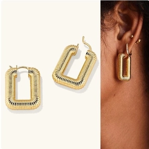 Orecchini a cerchio quadrati dorati con design a spirale mostrati su modella e still life
