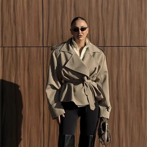 Women's khaki short trench coat with waist belt in a loose fit casual style
