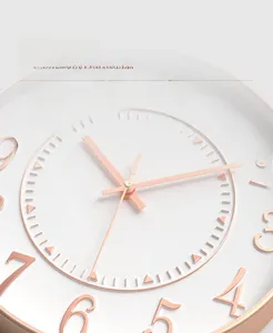Detailed view of rose gold 3D numbers and slim metal hands on a modern wall clock
