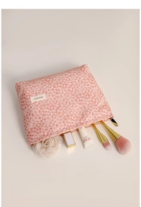 Detailed macro view of pink dotted cosmetic bag with sturdy zipper and brand label