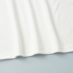 Close-up of white knit fabric texture and high-quality double-needle stitching on hem