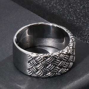 Vue macro d'une bague en acier argenté avec texture tressée et surface polie miroir
