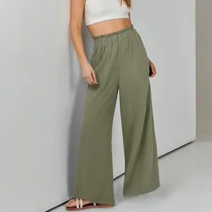 Dettaglio di pantaloni larghi in cotone e lino verde oliva a vita alta con elastico e tasche