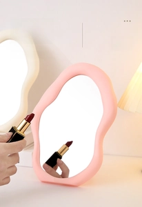 Close-up of pink cloud-shaped HD vanity mirror with decorative wavy frame