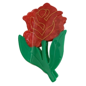 Elegant red rose hair claw clip with golden petal outlines and green leaves on white background