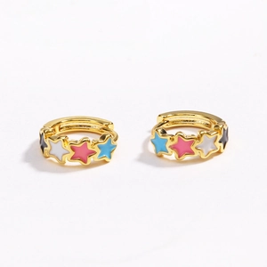 Close-up of gold ear hoops with colorful enamel star charms in black, white, and pink