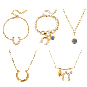 Golden horseshoe and clover charm jewelry set including necklaces and bracelets