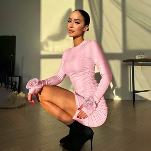 Detail of pink long sleeve mini dress featuring 3D rose cuffs and side ruched design