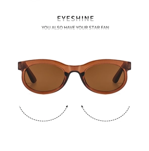 Detail view of oval amber sunglasses with lightweight resin frame and brown lenses