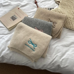 Three folded knit scarves in beige, grey, and khaki with cute bow tie embroidery details