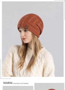 Detail of caramel orange knit beanie featuring thick cable texture and mountain leather patch