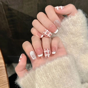 Gros plan d'ongles French cat-eye roses avec motifs à carreaux et paillettes argentées