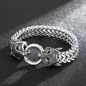 Close-up of vintage wolf head steel bracelet with intricate engraved links and ring
