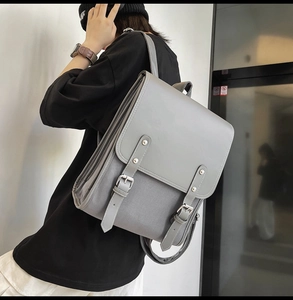 Gray retro soft leather backpack shown from a side view on a model in school style