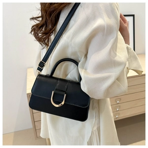 Detail of black PU leather shoulder bag with D-shaped metal buckle and adjustable strap
