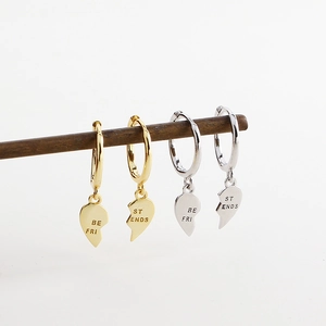 Close-up of gold and silver heart earrings with Best Friends engraved lettering