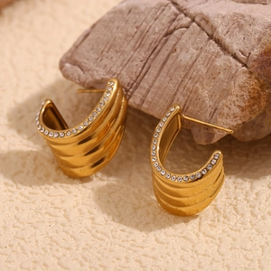 Close-up of gold plated wave earrings with micro-inlaid sparkling white diamonds