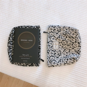 Macro shot of black and white floral jacquard makeup bags with textured fabric and zippers