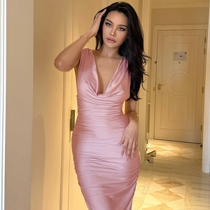 Dettaglio dell'abito aderente in raso rosa con profondo scollo a V e trama in seta lusso