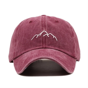 Détail de la broderie montagne blanche sur une casquette en coton délavé bordeaux