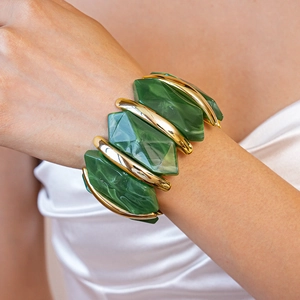 Gros plan sur le bracelet élastique large avec résine marbrée vert émeraude et barres dorées