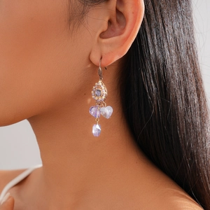 Side view of model wearing vintage purple crystal drop earrings with heart and teardrop design
