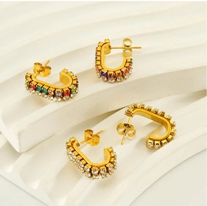 Macro detail of U-shaped gold stainless steel earrings with sparkling crystal pavé stones