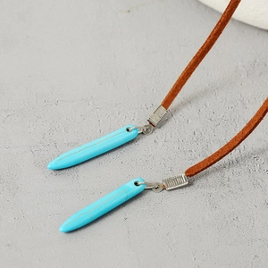 Detail of turquoise cone pendants with gold veins on brown suede necklaces