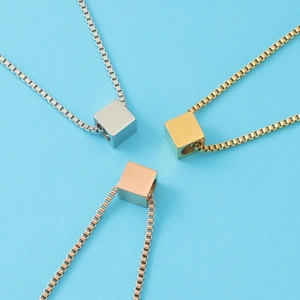 Three minimalist titanium steel necklaces with cube pendants in silver gold and rose gold