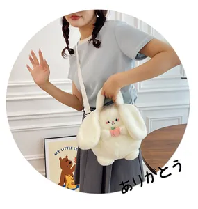 Close-up of white plush bunny crossbody bag with pink bow and peach detail on soft faux fur