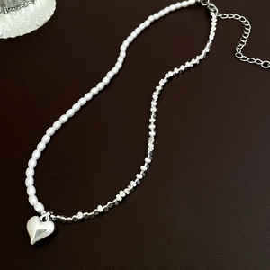 Détail du collier cœur élégant avec perles blanches et perles carrées en métal argenté